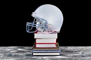 Football helmet sits on top of a stack of books on a marble counter